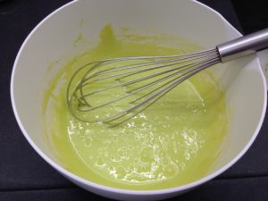 Dans un plat, fouetter les jaunes, le sucre, la crème fraîche, les colorants, l'arôme et la maïzena.