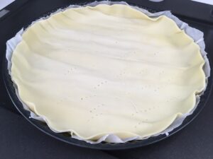 Etaler la pâte sur un moule à tarte et percer avec une fourchette pour ne pas qu'elle gonfle