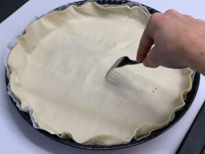Recette quiche aux champignons mozzarella et lardons -Ajouter les lardons et les champignons et verser sur le fond de tarte préalablement piqué à la fourchette.