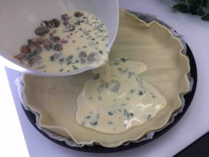Recette quiche aux champignons mozzarella et lardons -Ajouter les lardons et les champignons et verser sur le fond de tarte préalablement piqué à la fourchette.