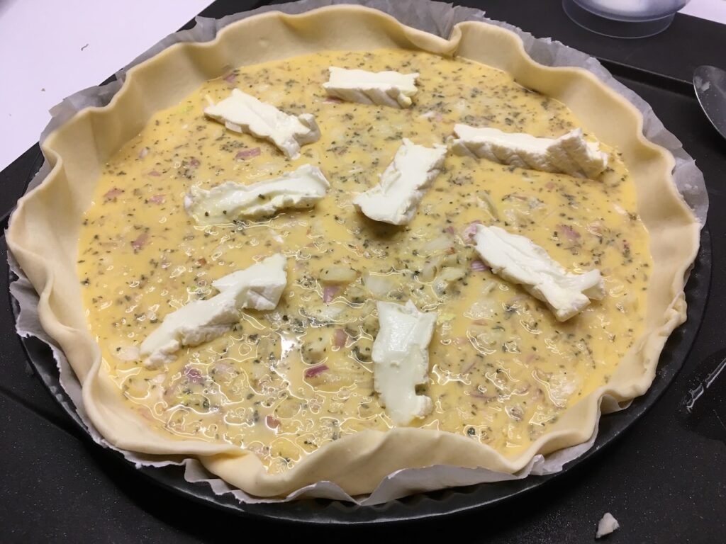 Recette quiche au fromage de brebis et aux herbes -Couper le fromage de brebis en morceaux et déposer-le sur la tarte