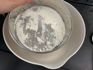 Recette gâteau à la crème pâtissière et à la rhubarbe -Ajouter la farine et la levure mélangées et tamisées. L'étape du tamis est importante car cela change fortement la consistance de la pâte.
