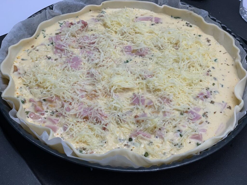 Recette quiche aux herbes de provence lardons et jambon -Parsemer de gruyère et enfourner 25 min à 180°C.