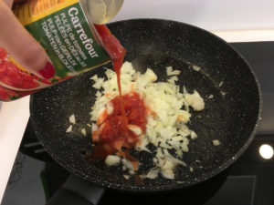 Reprendre la même poêle et faites-y dorer les oignons et l'ail, puis ajouter la pulpe de tomate, le paprika, le sucre, le thym et le laurier.