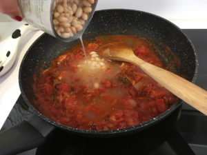 Ajouter les haricots et les morceaux de saucisses.