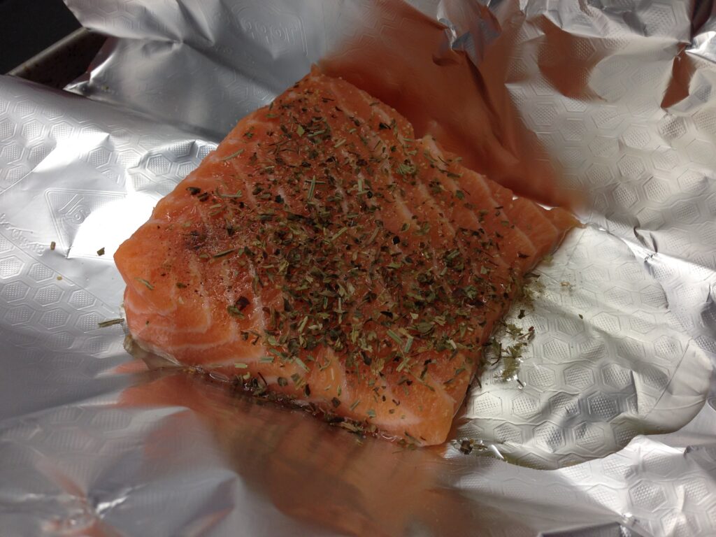 Dans un plat pouvant aller au four, déposer le pavé de saumon sur une feuille d'aluminium.
Recouvrir d'huile d'olive, d'ail et d'herbes de provence.
Saler, poivrer.