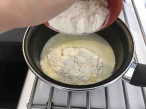Recette chouquette au sucre - Retirer du feu et ajouter la farine. Mélanger avec une cuillère en bois pour obtenir une pâte lisse.