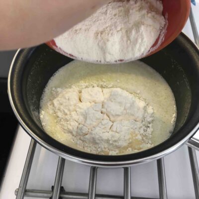 Recette chouquette au sucre - Retirer du feu et ajouter la farine. Mélanger avec une cuillère en bois pour obtenir une pâte lisse.