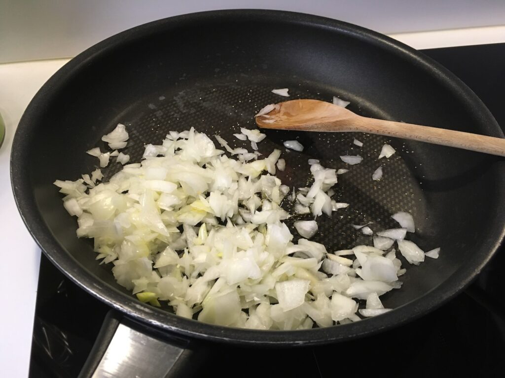 Recette lasagnes à la courge butternut -Faire revenir l'oignon et l'ail dans une poêle avec un filet d'huile d'olive