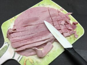 Recette tagliatelles aux légumes - Pendant ce temps, couper le jambon et ajouter-le dans un saladier avec la crème. Poivrer et saler.