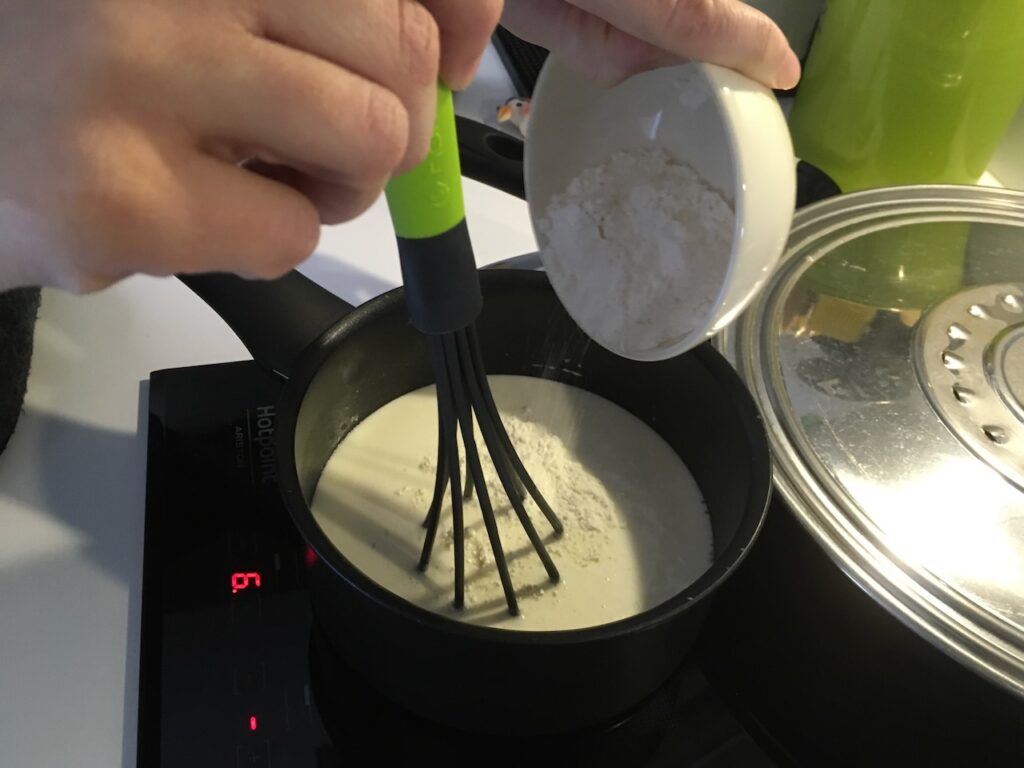 Cassolettes aux Saint-Jacques -Préparer la sauce: dans une casserole chauffée à feu doux, verser le vin blanc, la crème fraîche, le jus de cuisson des noix de Saint-Jacques. Fouetter et ajouter la farine pour épaissir la préparation.