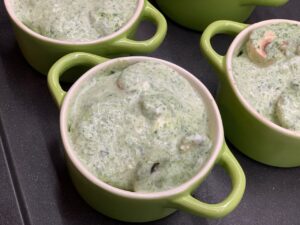 Recette mini gratins de pommes de terre champignons et épinards -Dans un plat mélanger la crème fraîche, l'ail et les épinards. Saler et poivrer. Répartir dans les cocottes.