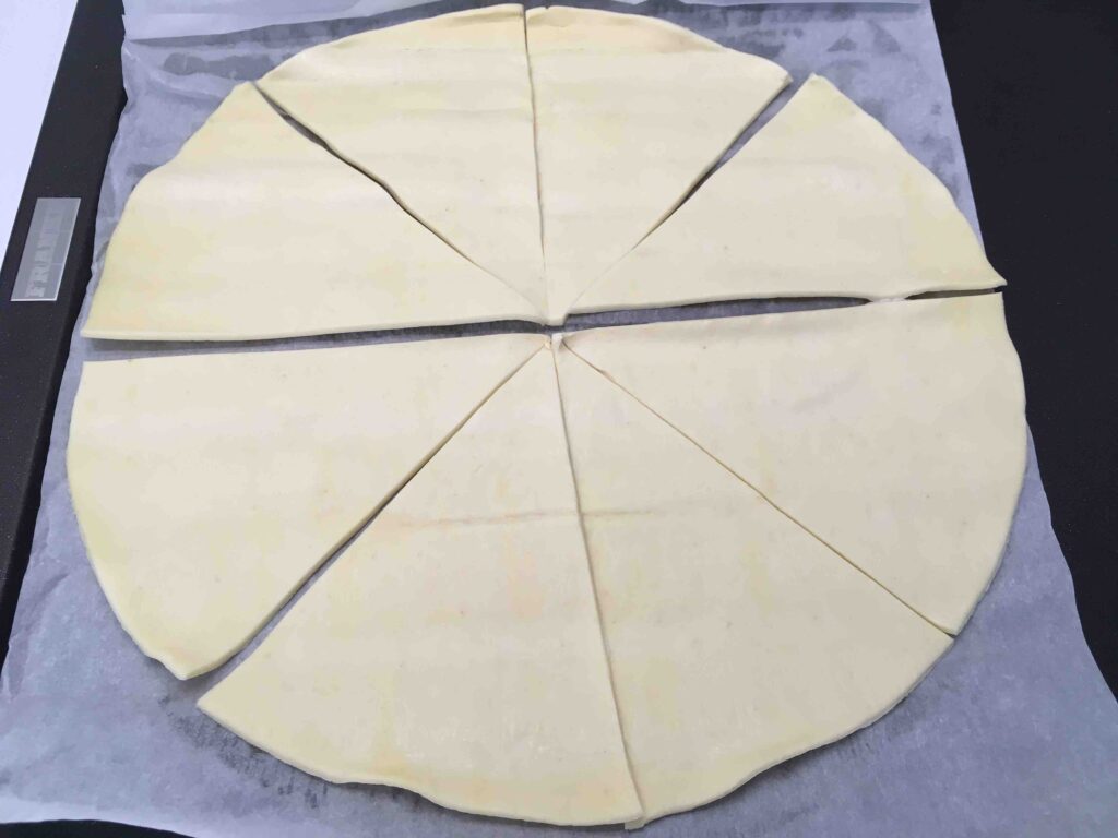 Recette minis croissants feuilletés à la coppa et au parmesan - Etaler la pâte et la couper en 10 parts.