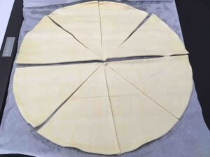 Recette minis croissants feuilletés à la coppa et au parmesan - Etaler la pâte et la couper en 10 parts.