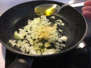 Recette cuisse de poulet gratinées -Faire revenir les oignons et l'ail haché quelques minutes avec l'huile d'olive.