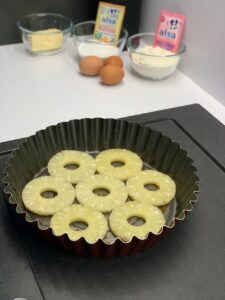 Recette gâteau renversé à l'ananas -Disposer les tranches d'ananas préalablement égouttées.