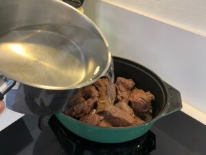 Recette t'fina de blé au boeuf confit - Remettre la viande et couvrer de 2 litres d'eau chaude. Saupoudrer de fond de veau et de paprika et mélanger. Ajouter les pois chiches.
