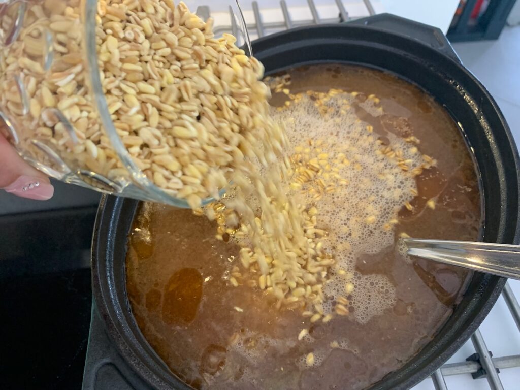 Recette t'fina de blé au boeuf confit -Au bout des 2h, ajouter la tête d'ail entière, le blé, la coriandre et le miel. Poursuivre la cuisson 2h, le liquide doit réduire des trois quarts donc ne pas couvrir pour bien laisser évaporer.
