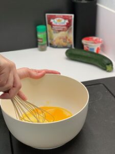 Recette minis flans aux courgettes - Dans un saladier, mélanger les oeufs, la crème fraîche, le parmesan et la ciboulette.