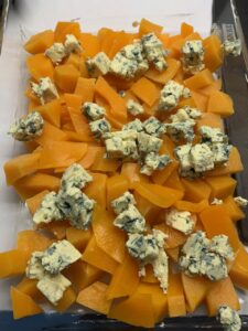 Recette gratin de butternut à la fourme d'Ambert -Beurrer un plat à gratin. Déposer les dés de courge. Emietter la fourme dessus.