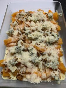 Recette gratin de butternut à la fourme d'Ambert -Verser le bol sur le plat puis parsemer de noix et de parmesan.