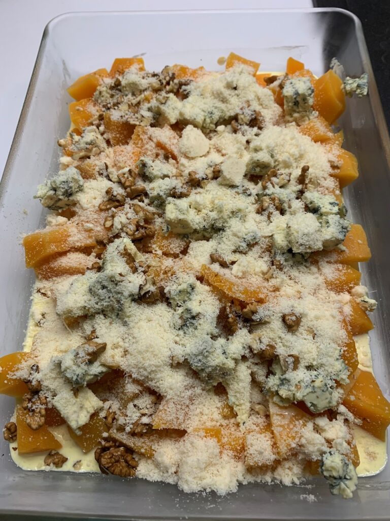 Recette gratin de butternut à la fourme d'Ambert -Verser le bol sur le plat puis parsemer de noix et de parmesan.