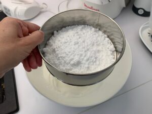 Recette Trianon -Tamiser le sucre glace et la farine sur les blancs en neige.