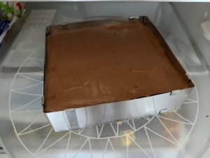 Recette Trianon - Verser la mousse au chocolat sur le croustillant en la répartissant bien aux 4 coins. Lisser la surface à l'aide d'une spatule. Réserver toute une nuit au réfrigérateur.