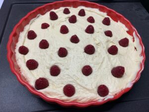 Recette gâteau à la ricotta chocolat blanc et framboises -Beurrer un moule de 24 cm de diamètre et y verser la pâte. Lisser et répartir les framboises sur le dessus en les enfonçant légèrement.