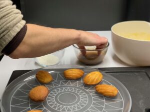 Recette madeleines au chocolat et noix de coco - Démouler et tremper les madeleines sur une seule face dans le chocolat fondu d'abord, puis dans la noix de coco.