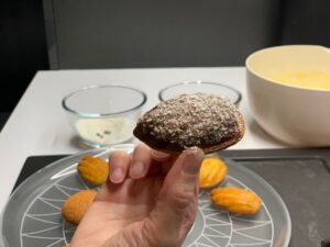 Recette madeleines au chocolat et noix de coco - Démouler et tremper les madeleines sur une seule face dans le chocolat fondu d'abord, puis dans la noix de coco.
