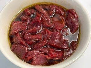 Recette wok de boeuf et nouilles chinoises -Couper les pavés de boeuf en fines tranches puis les laisser reposer dans la marinade quelques minutes.