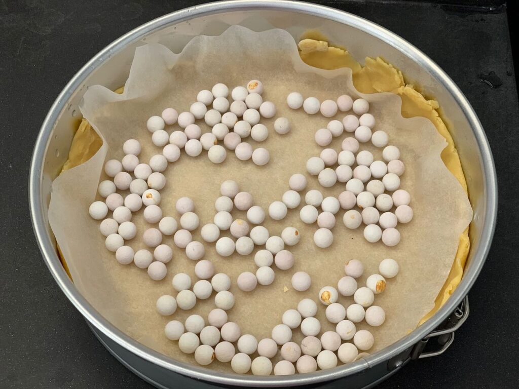 Recette tarte cookies aux pépites de chocolat et M&Ms -Après refroidissement, couvrir la pâte de papier cuisson et recouvrir de billes de cuisson.
Ces billes permettent d'éviter que la pâte ne gonfle.
Faire cuire au four à 170°C pendant 15 min.