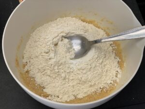 Recette tarte cookies aux pépites de chocolat et M&Ms -Incorporer l'oeuf puis la farine et la levure.
