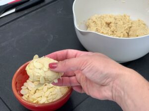 Recette macarons aux amandes effilées -Former des boules et les rouler dans les amandes effilées. Serrer-les bien à la main pour faire coller les amandes à la pâte.