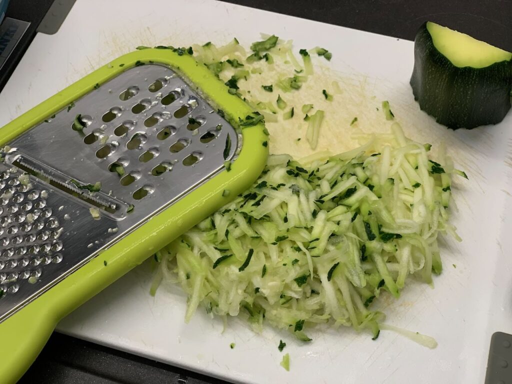 Recette quiche aux courgettes fromage et jambon -Laver les courgettes, enlever les 2 extrémités, retirer les pépins et râper-les avec la peau.