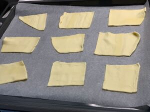 Recette tartelette au confit d'oignon et chèvre -Couper la pâte feuilletée en petits carrés et les positionner sur une plaque de four recouverte de papier sulfurisé. Piquer chaque carré plusieurs fois à la fourchette.
