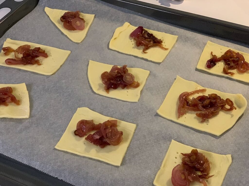 Recette tartelettes au confit d'oignon et chèvre - Mettre une cuillère de confit sur chaque carré de pâte.