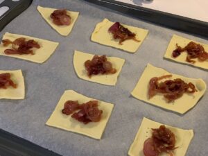 Recette tartelettes au confit d'oignon et chèvre - Mettre une cuillère de confit sur chaque carré de pâte.