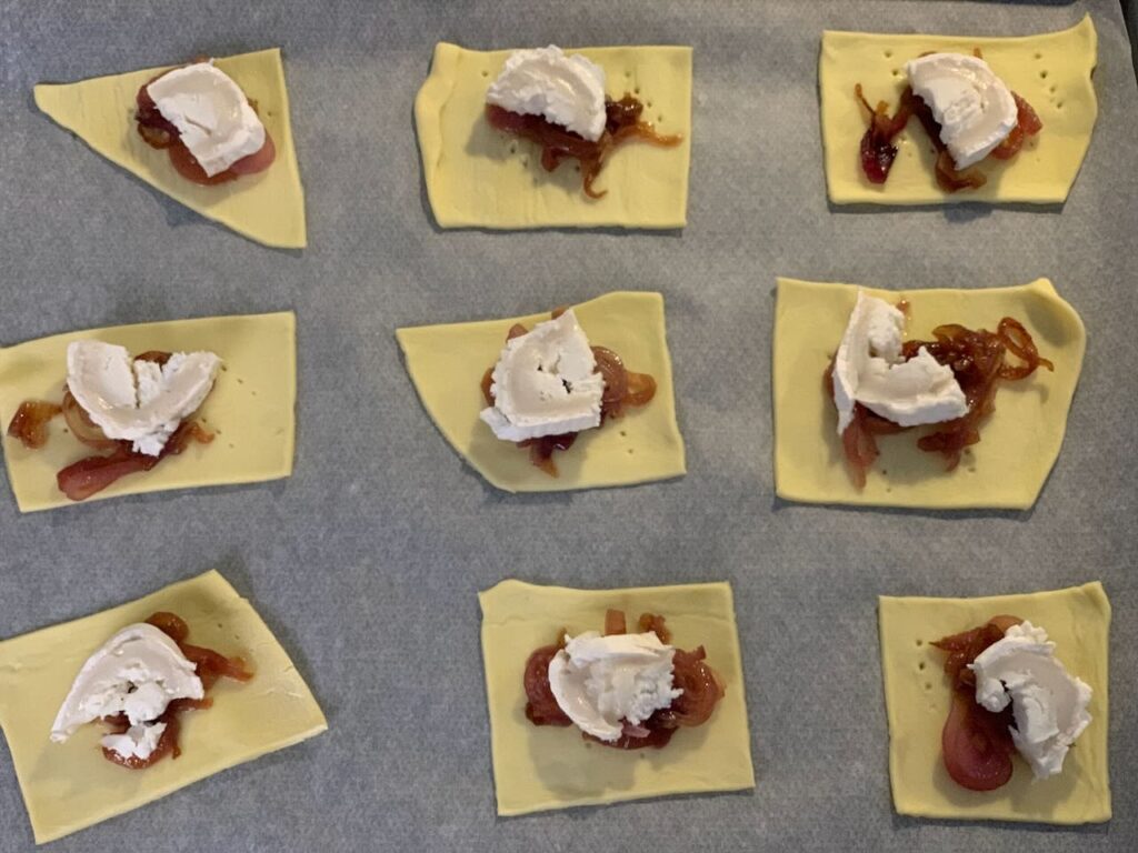 Recette tartelettes au confit d'oignon et chèvre - Couper le chèvre en carrés et ajouter en un morceau sur chaque bouchée.