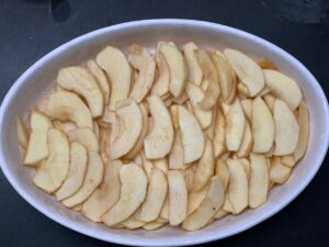 Recette clafoutis à la pomme -Beurrer et fariner un moule pouvant aller au four. Disposer les lamelles de pommes dedans.