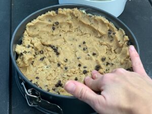 Recette maxi cookie nutella -Beurrer un moule et étaler les 3/4 de la pâte en aplatissant légèrement au fond et sur les côtés.