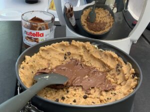 Recette maxi cookie nutella -Recouvrir de nutella et terminer en émiettant le reste du cookie par dessus.