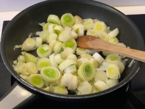 Recette velouté de poireaux et pommes de terre au pesto -Dans une casserole, faites revenir l'oignon et les poireaux dans le beurre avec un peu de sel pendant une dizaine de minutes à feu moyen.