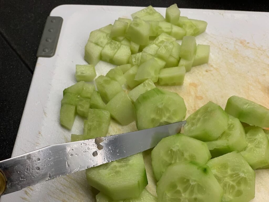 Recette verrines concombre saumon - Couper le concombre en petits morceaux et le disperser dans le fond des verrines.