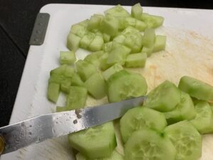 Recette verrines concombre saumon - Couper le concombre en petits morceaux et le disperser dans le fond des verrines.
