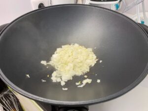 Recette riz frit thaïlandais -Emincer l'ail et l'oignon et faites-les revenir dans l'huile dans un wok ou une poêle.