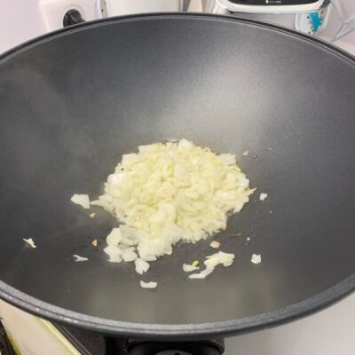 Recette riz frit thaïlandais -Emincer l'ail et l'oignon et faites-les revenir dans l'huile dans un wok ou une poêle.