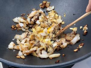 Recette riz frit thaïlandais -Ajouter l'oeuf dans un coin et mélanger-le rapidement pour obtenir une fine omelette.