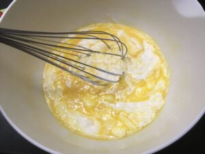 Recette quiche aux tomates et aux courgettes - Dans un saladier, fouetter les oeufs avec la crème, le parmesan et la muscade. Saler et poivrer.